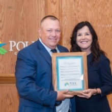 Circuit Judge Susan L. Barber holding Proclamation declaring May 2024 PSC and Opioid and Substance Abuse Awareness Month. On her right is Polk County Attorney Randy Mink. 